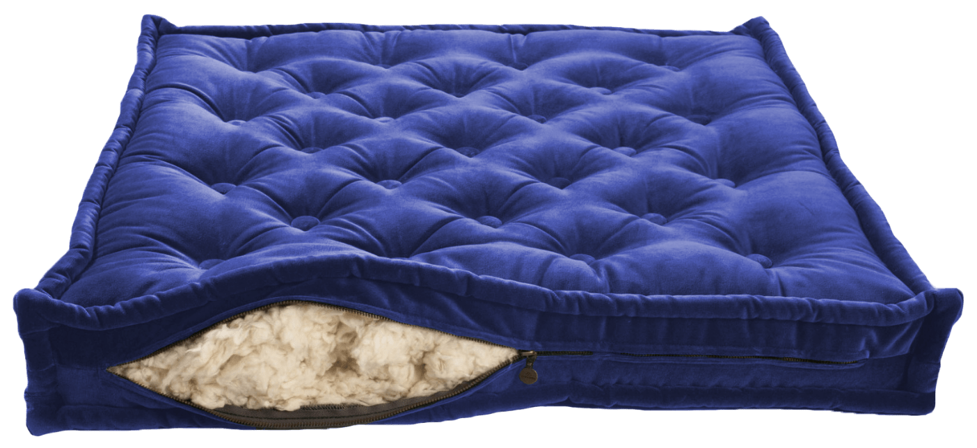 tuftad fransk madrass i blått överdrag med öppen dragkedja och synlig bomullsfiling